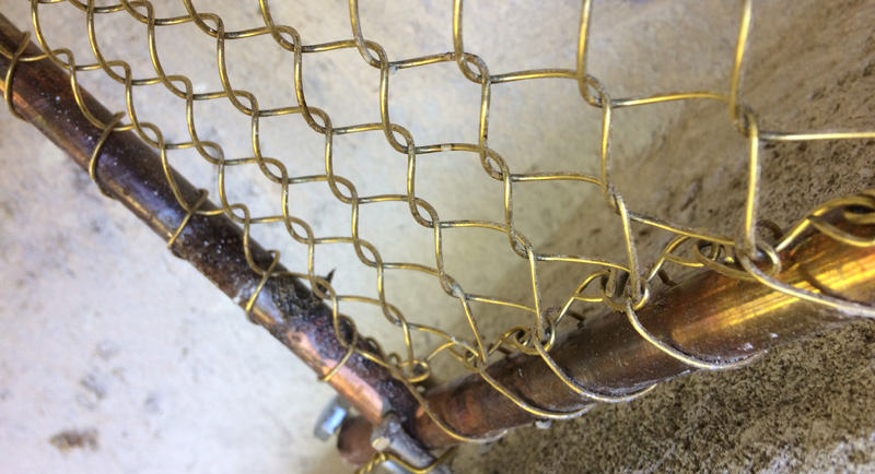Détail d’un grillage de protection en cuivre sur son cadre