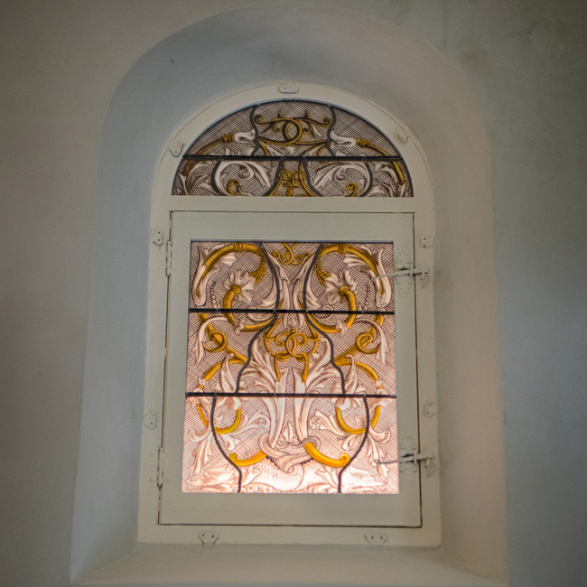 Fenêtre cintrée ornée de vitraux au Château de la Gaude